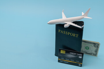 Passport, credit card, airplane, and 2 dollar bills isolated on blue background with copy space