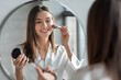 © Prostock-studio - Attractive Young Woman Doing Daily Makeup While Standing Near Mirror In Bathroom