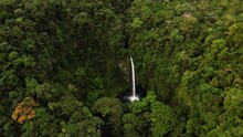 Focused Huge Incredible Waterfall Flowing In Dense Rainforest Environment 