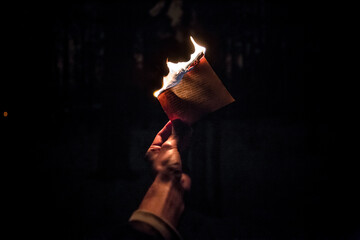 Wall Mural - Close-up shot of a person holding a burning paper