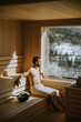 © BGStock72 - Young man relaxing in the sauna and watching winter forest through the window