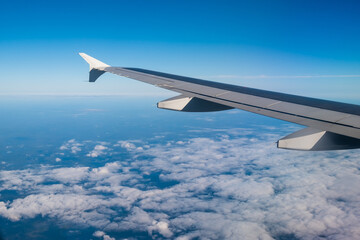 Wall Mural - aircraft wing view from airplane window seat, beautiful sky and cloud.