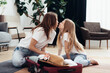 Mother and daughter kissing while preparing to travel