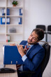 © Elnur - Young male employee and too much work in the office