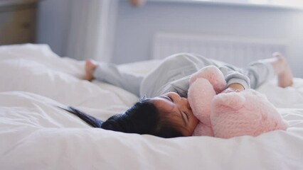 Wall Mural - Father in bed at home playing game with daughter and her toy - shot in slow motion