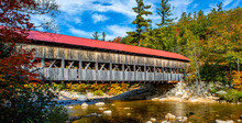 Beautiful Shot Of A Wooden Bridge With A Red Roof Going Over A Still River In A Colorful Forest