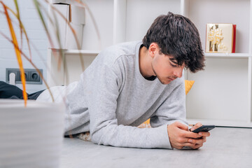 Wall Mural - young man with mobile phone at home