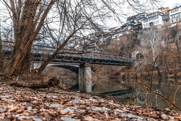 Sticker - Railroad bridge that goes over the lake into the tunnel in a mountain and buildings on top of it