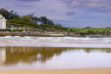 Sticker - View of the empty beach with the green vegetation in the background. Playas de Santander, Spain.