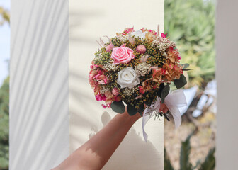 Wall Mural - Bride Hand Holding Beautiful Pink Wedding Bouquet Made by Florist with Dried Flowers