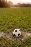 Fototapeta Sport - Classic foot ball on a green grass pitch. Outdoor training concept. Nobody. Sport theme background