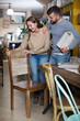 © JackF - Attractive girl with boyfriend choosing vintage chair in furnishings store