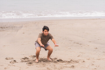 Young Hispanic man practicing various poses in yoga on the beach