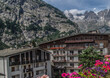 Apartment buildings in Courmayeur with Alpine mountains in the background on a sunny day