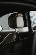 Vertical shot of headrest and a tablet in a luxury black car showroom