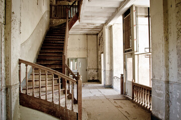 Sticker - Interior of an old abandoned building with a wooden stairway