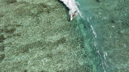 Wall Mural - Aerial view of a male surfer riding the huge waves