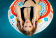 © Cavan Images - Amazing blonde with a beautiful figure lying in the pool on an a
