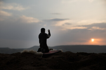 Silhouette of mosque building on toned foggy background. Ramadan Kareem background. Mosque at sunset. Praying people