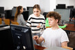 © JackF - Teenager helps friend solve problem on computer in a school class