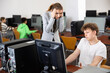 © JackF - Female teacher amazed by misbehavior of her student, teenage boy, during computer science lesson.