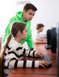 © JackF - Smart interested preteen schoolboy helping cute girl classmate sitting at computer during informatics lesson..