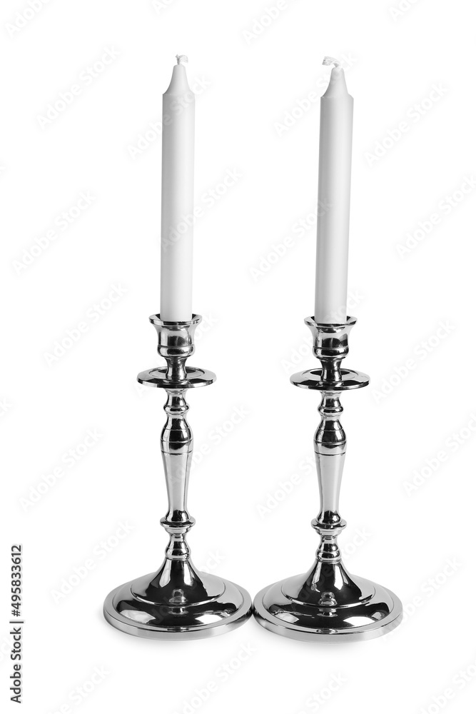 Wax candles in stylish holders on white background