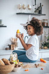 Wall Mural - Cute girl wuth bunny ears in the kitchen smiling happily