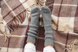 Leinwandbild Motiv Female legs in warm socks on plaid. Concept of heating season