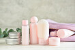 Travel bottles and jars with cosmetic products on light wooden table, closeup