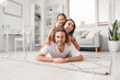 © Pixel-Shot - Happy young family lying on carpet at home