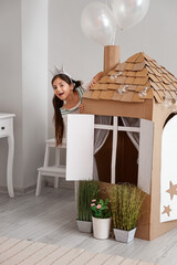 Sticker - Funny little girl playing with cardboard house at home