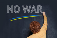 Child Boy Writing No War Inscription On School Blackboard Background. Stop War In Ukraine Concept