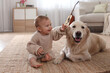 © New Africa - Cute little baby with adorable dog on floor at home