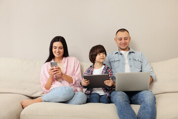 Poster - Happy family with gadgets on sofa at home