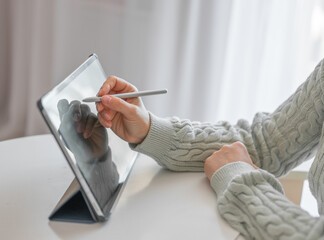 Wall Mural - female artist using smart stylus for drawing picture on tablet touch screen device, working home. Cropped view of woman using digital tablet with electronic pen at home