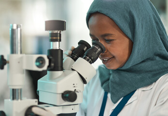 Wall Mural - conducting fair tests. shot of a young scientist using a microscope in a lab.