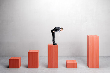 Canvas Print - Businessman on red chart bars on concrete wall background. Crisis, business and growth concept.