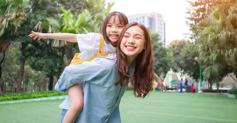 Asian mother and daughter playing together at park