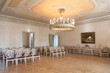 © Mint Images - A large room with parquet flooring, elegant chairs and tables, chandelier and dance floor.
