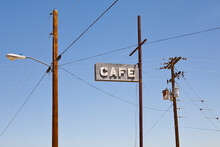 Cafe Sign High On A Pole, Electricity And Telephone Wiring On Posts. 