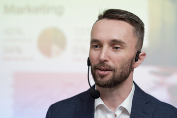 Poster - Young confident broker or business coach with microphone by his mouth making speech in front of audience at conference or seminar