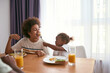 © Svitlana - Girl feeding her brother egg from fork near father