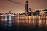 Fototapeta  - manhattan bridge and new york city skyline at night by the bay