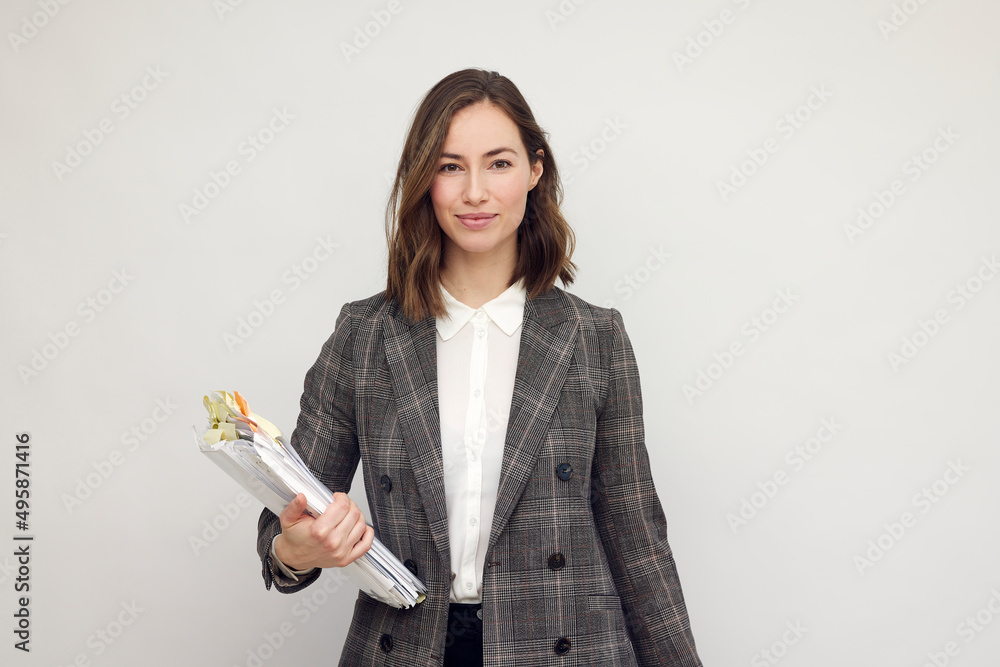 Beautiful and smiling business woman with paperwork in hands, standing ...