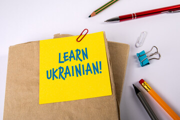 Wall Mural - Learn Ukrainian. Textbooks and stationery on a white table
