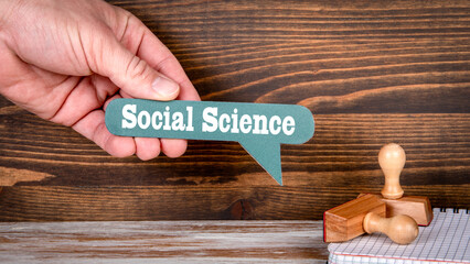 Social science. Green speech bubble with text in a man's hand