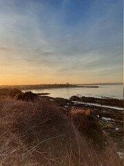 Wall Mural - Cityscape of St Andrews in Scotland, United Kingdom as seen from the Fife Coastal Path during sunset