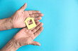 © Stockmachine - In the hands of an elderly man, a paper-cut house on a blue background. The concept of savings, mortgages and buying an apartment. Right copyspace.