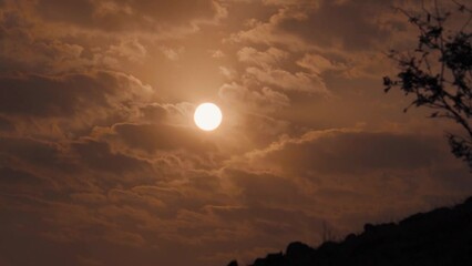 Wall Mural - Extreme Closeup shot of sun behind the clouds during the sunset. Sun during the sunset background. Natural sunset background	